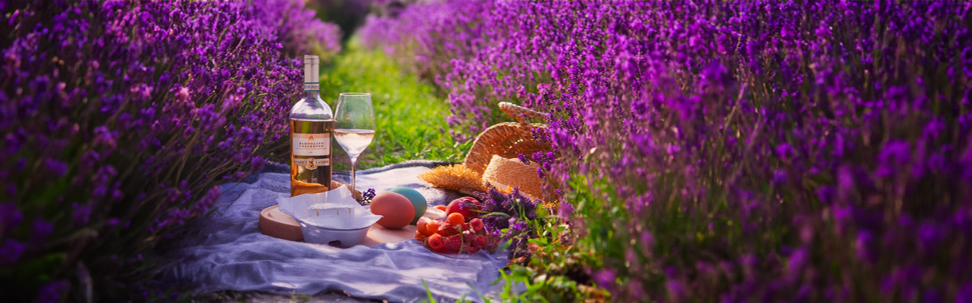 Oster Picknick mit Roséwein und Weinglas im blühenden Garten – Frühlingsstimmung mit Wein