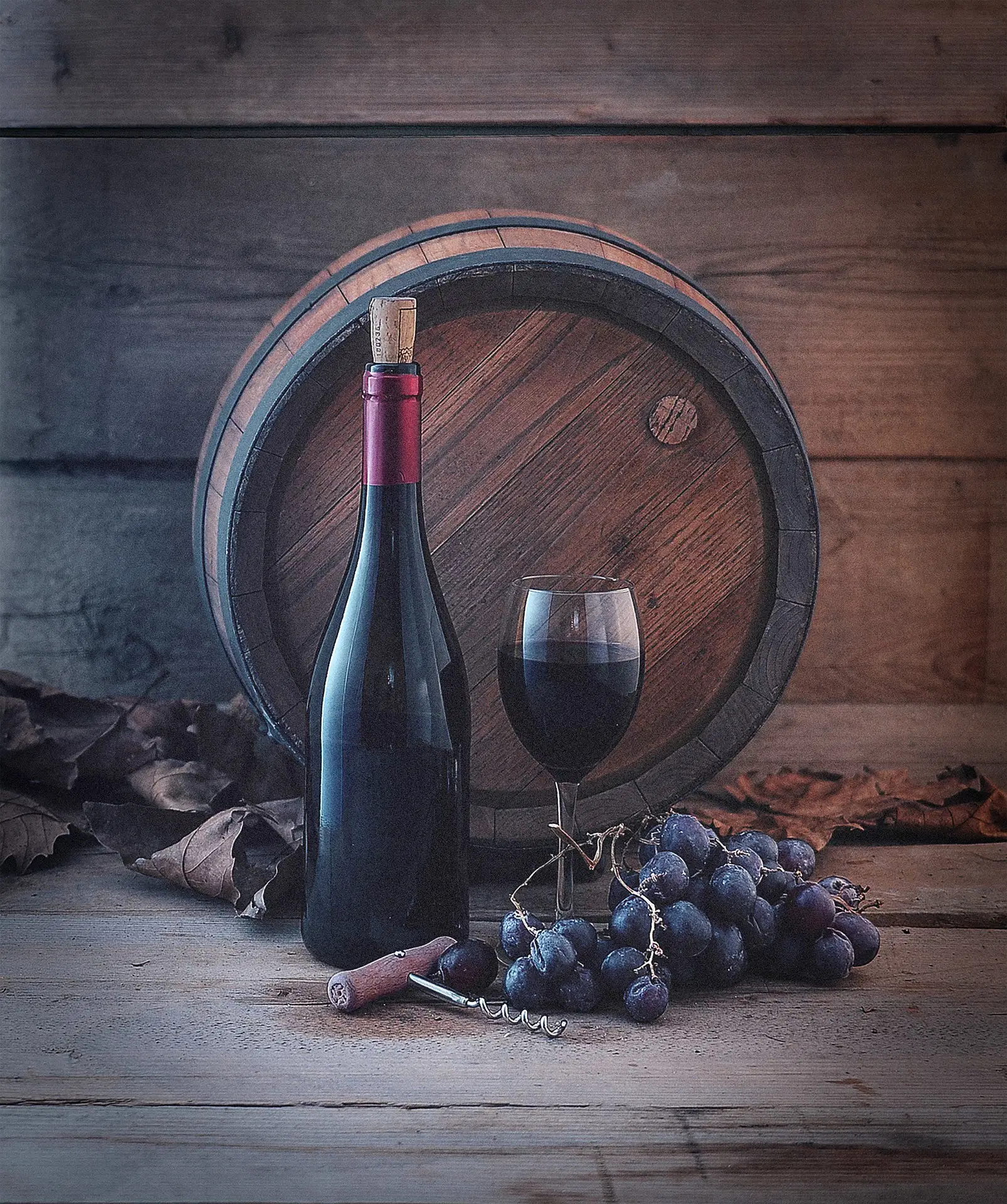Weinfass, Magnumflaschen, Glas Rotwein und Trauben